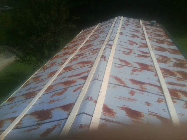 Rusted metal roof panels with new wood purlins before replacement — Storm Damage Roof Repair in Riceville by Roofing Brothers