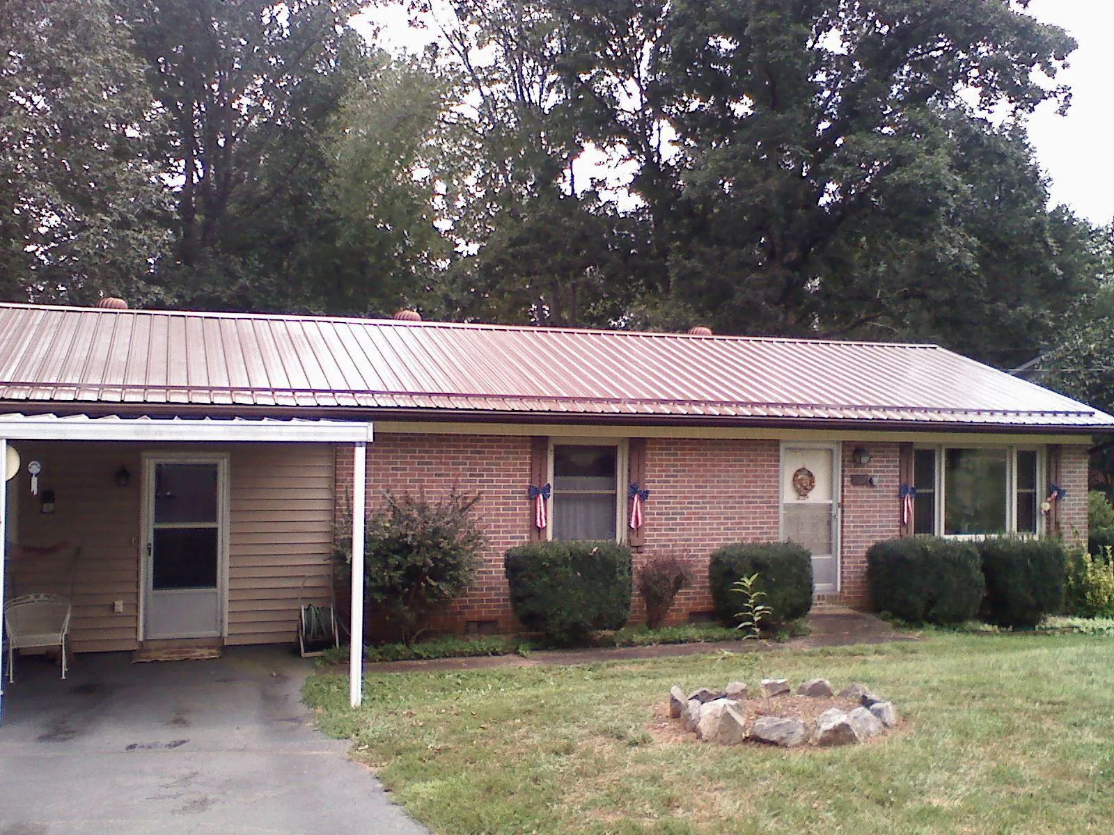 Bronze metal roof and carport on a brick ranch home — Roof Repair work by our crew in Riceville